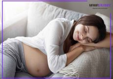 احساس خستگی در دوران بارداری خانم باردار خسته در حال استراحت بر روی مبل
