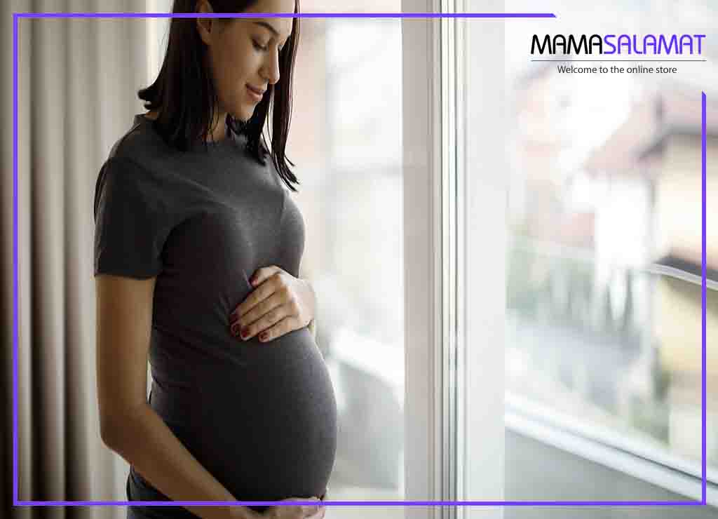 مراقبت‌های سه ماهه اول بارداری داشتن خانم باردار در آرامش ایستاده در کنار پنجره 